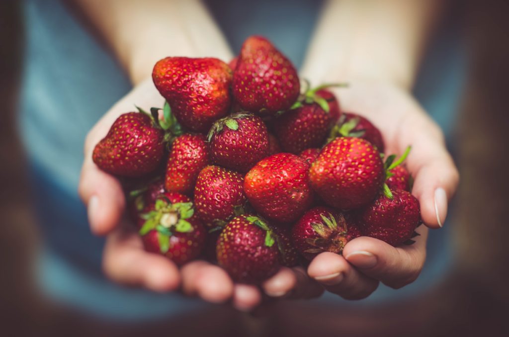 woman holding handful of strawberries